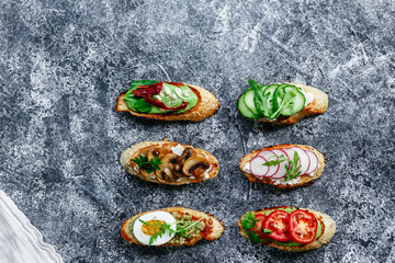 Bruschetta with mushrooms, cucumbers, avocado, radish, salmon and egg