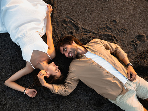 Attractive couple on vacation on the shore of the ocean at sunset time - Powered by Adobe