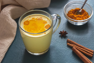 Golden milk with turmeric on a blue background