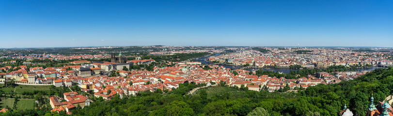 Fototapeta na wymiar Large panorama of the city of Prague in Czech Republic, from the Petrin hill. In foreground, the Mala Strana district with the castle. Then to the other side of the Vltava river, the old town.