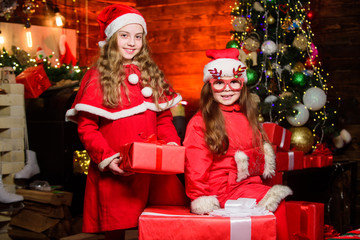 Obraz na płótnie Canvas Christmas is coming. small girl kids in red santa hat. wait for xmas gift. Happy family celebrate new year. Winter shopping sales. Little sisters want present. christmas time. Love winter holidays