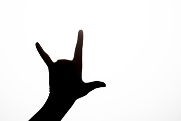 Black shadow gesture of human hand in form of two horns