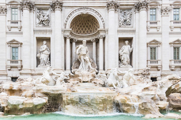 Fototapeta na wymiar Fountai of Trevi by Nicola Salvi in the Trevi district in Rome. The largest Baroque fountain in the city and one of the most famous ones in the world. Ca 3000 Euros are thrown into the water every day