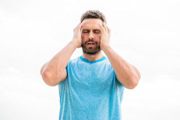 sportsman with athletic body. coach in fitness gym. after workout. man athlete in blue sport tshirt. sportswear fashion. male with beard. tired man isolated on white. he has headache. feel tired