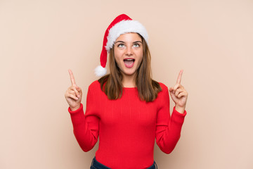 Fototapeta na wymiar Young girl with christmas hat over isolated background pointing with the index finger a great idea