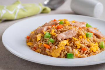 Fried rice chicken with egg and vegetables on white plate.