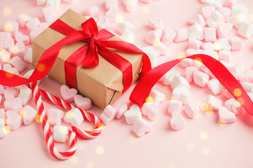Gift box with red ribbon bow, copy space for your text, Happy Saint Valentine day background, sweet marshmallow on pink table, banner