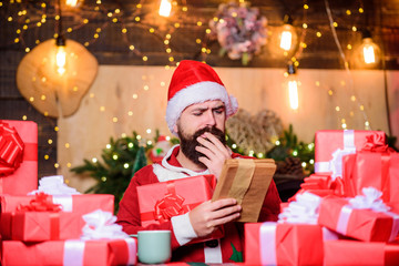 Fototapeta na wymiar Buy christmas presents. December purchases. Old tradition. Santa Claus routine. Preparing gifts. Man Santa hat preparing for christmas holiday. Merry christmas concept. Winter carnival. Shopping list
