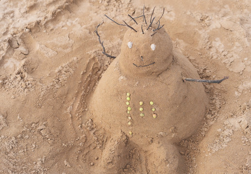 New Year or Merry Christmas sand snowman on ocean beach.