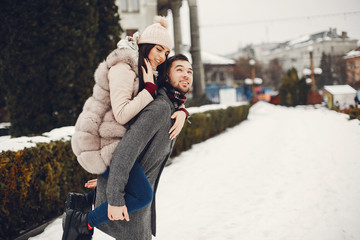 Couple in a winter park. Beautiful girl in a fur coat. Man in a jeans jacket.