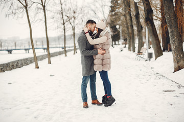 Fototapeta na wymiar Couple in a winter park. Beautiful girl in a fur coat. Man in a jeans jacket.