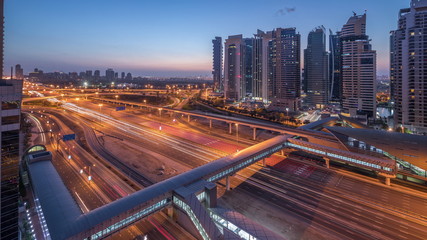 Obraz na płótnie Canvas Aerial top view to Sheikh Zayed road near Dubai Marina and JLT night to day timelapse, Dubai.