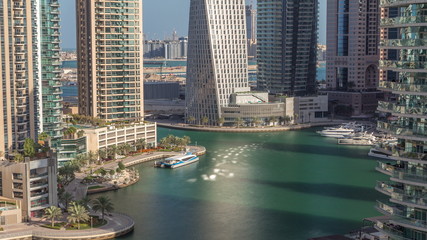 Fototapeta premium Widok z lotu ptaka na wieżowce mieszkalne i biurowe Dubai Marina z timelapse waterfront