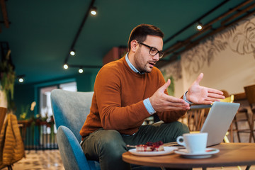 Portrait of a casual businessman having online meeting in a cafe.