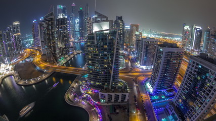 Obraz premium Aerial view of Dubai Marina residential and office skyscrapers with waterfront night timelapse