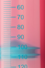 Syringe on pink background close-up, copy space. T