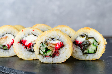 baked sushi on a black stone