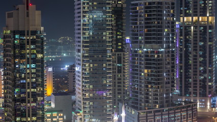 View of various skyscrapers and towers in Dubai Marina from above aerial night timelapse