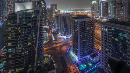 Fototapeta na wymiar View of various skyscrapers and towers in Dubai Marina from above aerial night timelapse