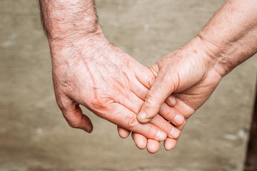 Close-up photo of elderly people holding hands. Hand gestures, loving, care