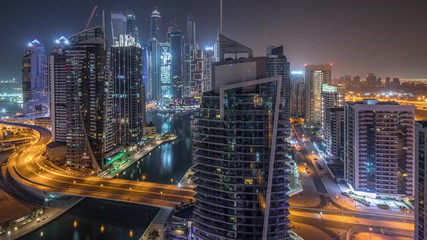Fototapeta na wymiar Aerial view of Dubai Marina residential and office skyscrapers with waterfront night timelapse