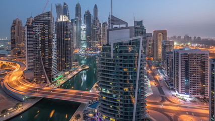 Aerial view of Dubai Marina residential and office skyscrapers with waterfront night to day timelapse