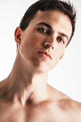 Obraz premium Portrait of handsome young man posing over white background. Perfect hair & skin. Close up. Studio shot