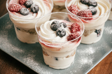 dessert with cream and berries in glass