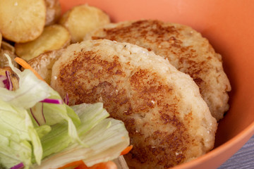 Chicken cutlets, served with potatoes and salad