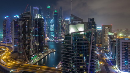 Fototapeta na wymiar Aerial view of Dubai Marina residential and office skyscrapers with waterfront night timelapse hyperlapse