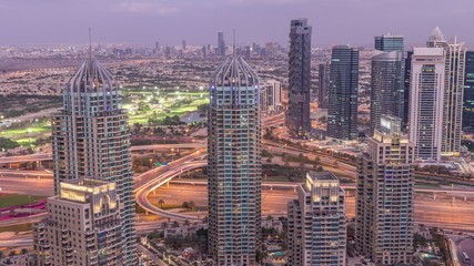 Dubai Marina skyscrapers and jumeirah lake towers view from the top aerial day to night timelapse in the United Arab Emirates.