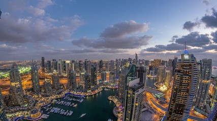 Dubai Marina skyscrapers and jumeirah lake towers view from the top aerial day to night timelapse in the United Arab Emirates.