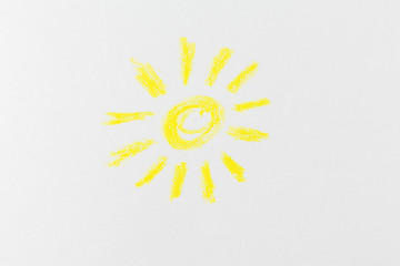 chalked yellow sun with rays on white paper. minimalistic primitive drawing