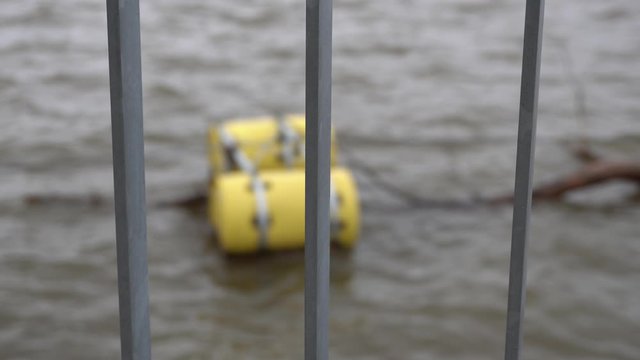 A cool close-up view on the fence and you can see the water in the background. On the water, you can see yellow floats as a warning not to go further.