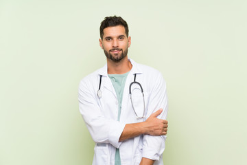 Young doctor man over isolated green wall