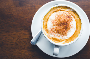top view close up modern hot black coffee the cappuccino on wood background with coffee bubble foam pattern and texture in white cup looking and feel so delicious on glasses table in coffee shop.