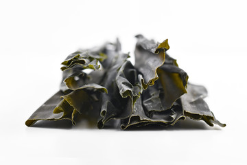 Dried sheets of kombu, an edible kelp algae, also called  dasima or haidai, that is widely eaten in East Asia and especially Japan, isolated on white background - obrazy, fototapety, plakaty