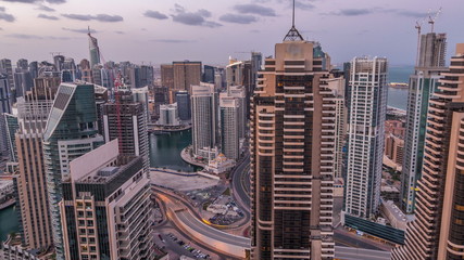 Fototapeta na wymiar Dubai Marina skyscrapers and jumeirah lake towers view from the top aerial night to day timelapse in the United Arab Emirates.