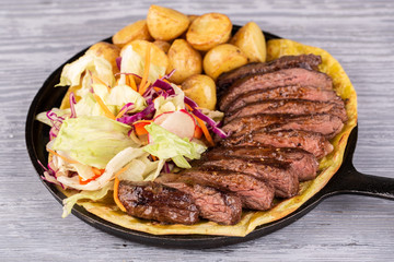 Turkey meat, served in pieces on a lavash with potatoes and greens