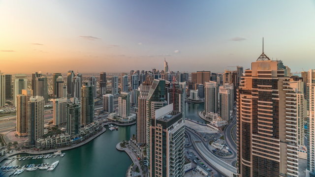 Dubai Marina skyscrapers and jumeirah lake towers sunrise view from the top aerial timelapse in the United Arab Emirates.