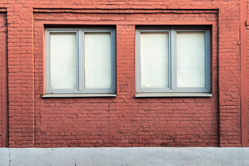 Brick facade of the building with two windows.
