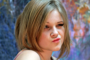 Fototapeta premium Portrait of a natural blonde. A teenage girl with a light make-up squinted thoughtfully