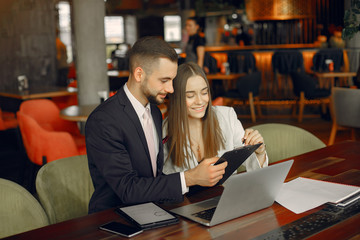 Man and beautiful woman working. People in a cafe. Lady in a elegant suit