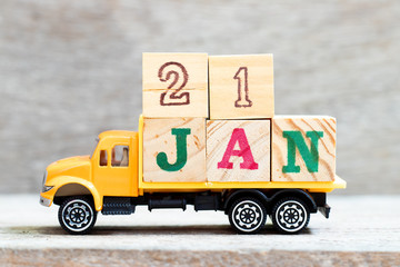 Truck hold letter block in word 21jan on wood background (Concept for date 21 month January)