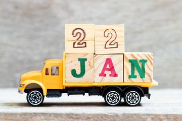 Truck hold letter block in word 22jan on wood background (Concept for date 22 month January)