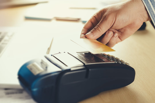 Payment terminal with card on table - Powered by Adobe