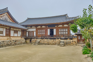 Obraz premium Scenic view of old traditional korean house in Hahoe folk village near Andong in South Korea. Beautiful summer cloudy look of building in traditional asian style in small town in Republic of Korea.