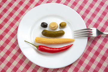 olives, pickled cucumber, red hot peppers, mushrooms and corn in a salad on a plate. food and vegetables. diet and weight loss
