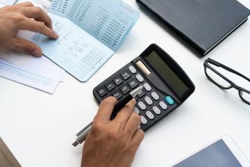 Man using calculator with doing finance at home office.