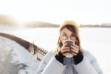Happy young teenage woman holding a takeaway coffee cup